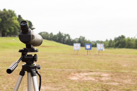 Spotting scope on tripod at outdoor archery target range