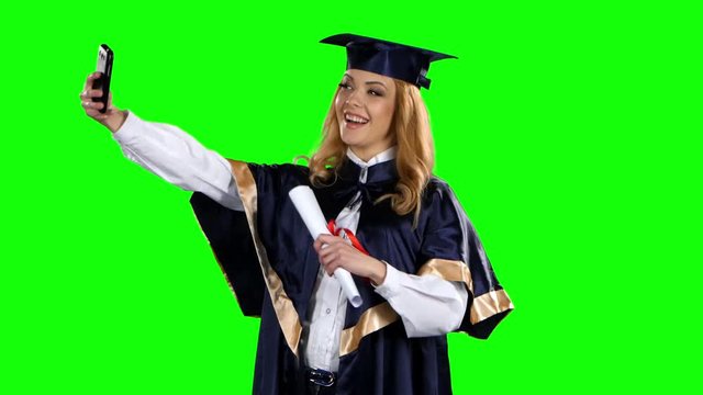 Graduate take selfe photo with diploma. Green screen