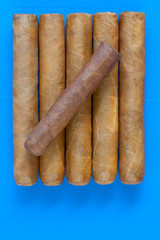 Detail of luxury Cuban cigars on the blue desk