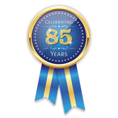 Fototapeta premium Blue celebrating 85 years badge, rosette with gold border and ribbon