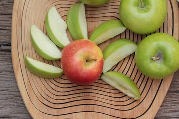 green and red apples on wood background.