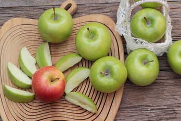 green and red apples on wood background.