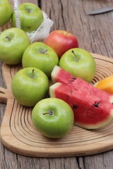 apples and watermelon delicious on wood background.