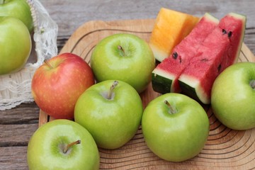 apples and watermelon delicious on wood background.