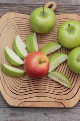 green and red apples on wood background.