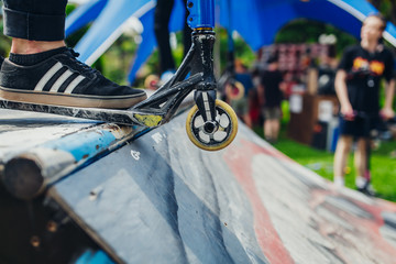 man leg scooter at skatepark ramp