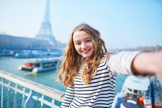 Young girl taking selfie near the Eiffel tower