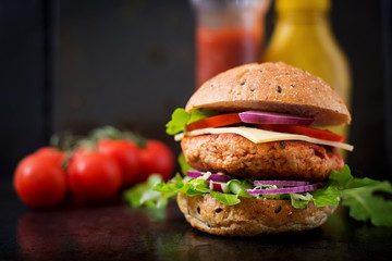 Big sandwich - hamburger with juicy chicken burger, cheese, tomato, and red onion on black...