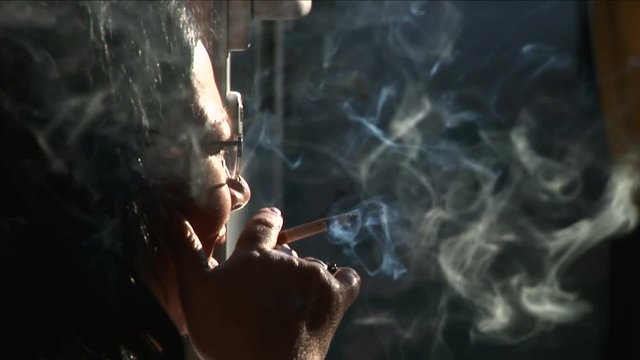 Senior woman heavily smoking, close-up
