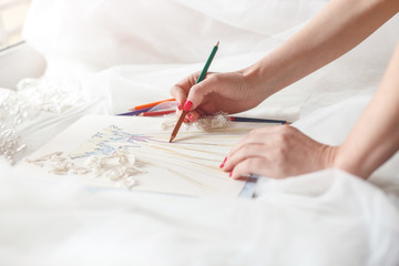 Cheerful female tailor is creating bridal gown