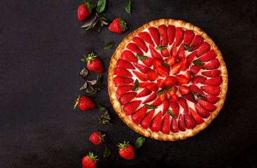 Tart with strawberries and whipped cream decorated with mint leaves. Top view