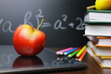 red apple on notebook with book stack