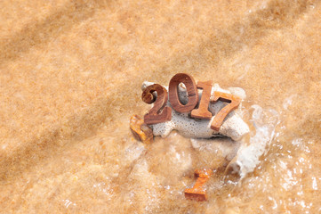 Change to 2017 with soft wave, wood number 2017 on beach background idea, happy new year concept