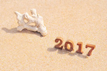 Fototapeta na wymiar Wood number 2017 on beach background idea, happy new year concept