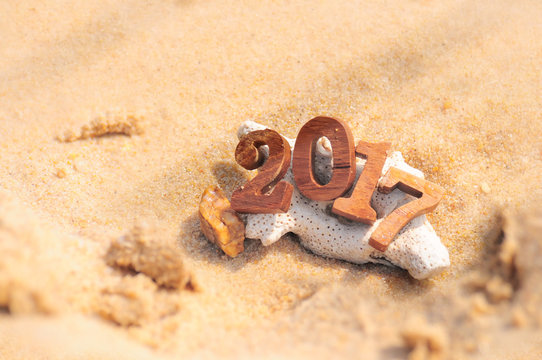 Wood number 2017 on beach background idea, happy new year concept