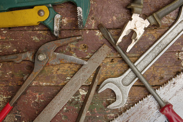 Heap of old instruments on wooden background. Wrench,file,screwdriver,pliers,scissors,saw.