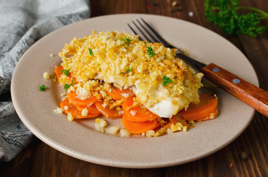 Oven-roasted fish fillet with carrots under a bread crust