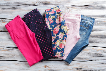 Jeans and trousers. Light pants with colorful print. Trendy female garments for spring. Dots and flowers.