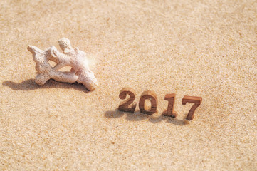 Wood number 2017 on beach background idea, happy new year concept