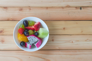 Naklejka na ściany i meble mixed fruit in white bowl on wood table