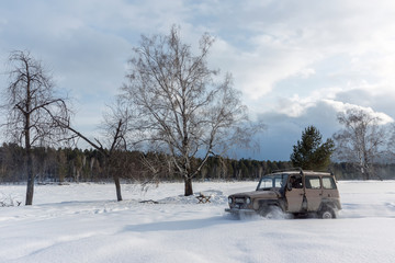 old SUV driving on a snowy field