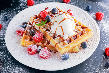 Belgian waffles with ice cream, chocolate sauce and fresh berries.
