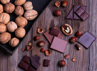 pieces of chocolate with various nuts on a wooden table