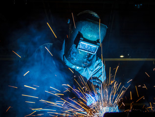 worker with protective mask welding metal
