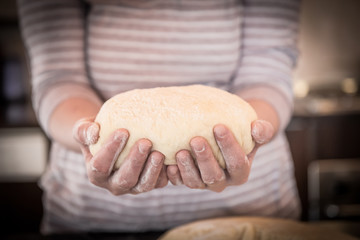 Female hands holding dough