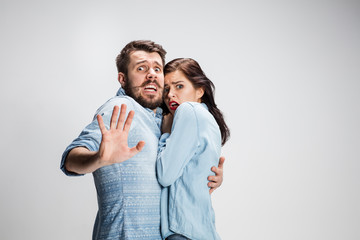 Emotional facial expression wide eyed couple, woman an man looking surprised open mouth