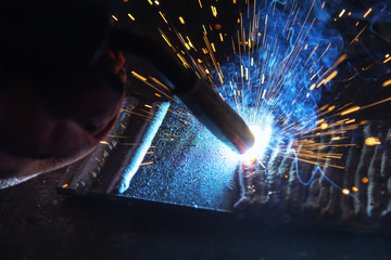 Fototapeta the welding spark light in close-up scene,the torch of welging machine with the spark light in blue obraz