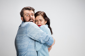 Emotional facial expression wide eyed couple, woman an man looking surprised open mouth