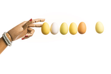 Woman's hand plays Newton's pendulum with eggs