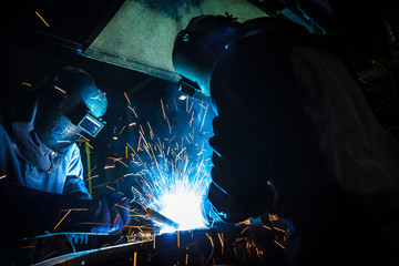 worker with protective mask welding metal