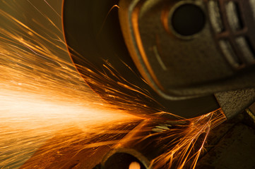 Sparks from cutting metal abrasive disk of angle grinder