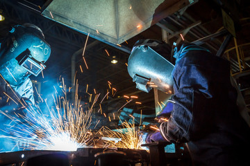 worker with protective mask welding metal