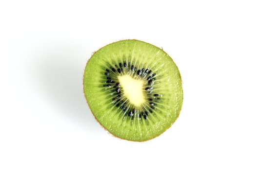 Cut in half kiwi fruit with green pulp and black seeds isolated on white background