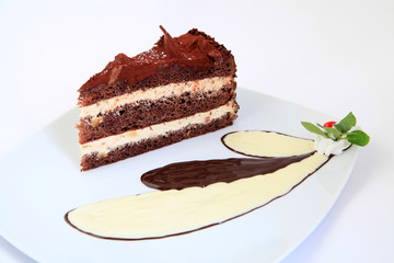 Piece of chocolate cake with decoration on white plate