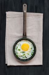 Fried egg in frying pan on napkin