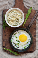 Fried egg in pan on cutting board