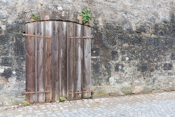 Old wooden gate in ancient wall
