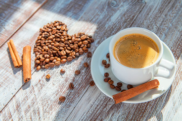 Heart shape made from coffee beans on wooden surface.