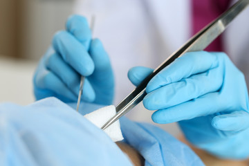 Surgeon hand hold scalpel and tweezers