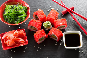Obrazy na Plexi  sushi i bułki z sałatką z zielonego morza na łupkowym stole