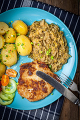 Fried pork chop, baked potatoes and fried young cabbage.