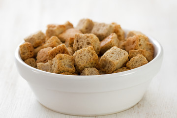 croutins in white dish on white wooden background