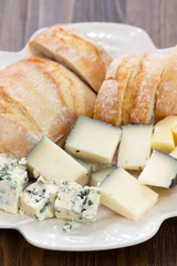 cheese with bread on white dish on brown wooden background