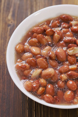 boiled beans in white dish on brown background