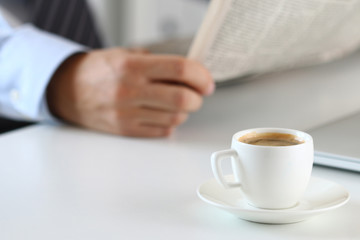 Cup of morning coffee with businessman on background