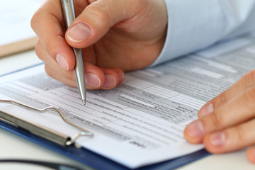 Fototapeta premium Close up of male accountant filling tax form